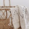 plaid tissé a la main en coton blanc crème avec dessins brodes noirs. Bali artisanat bambou living