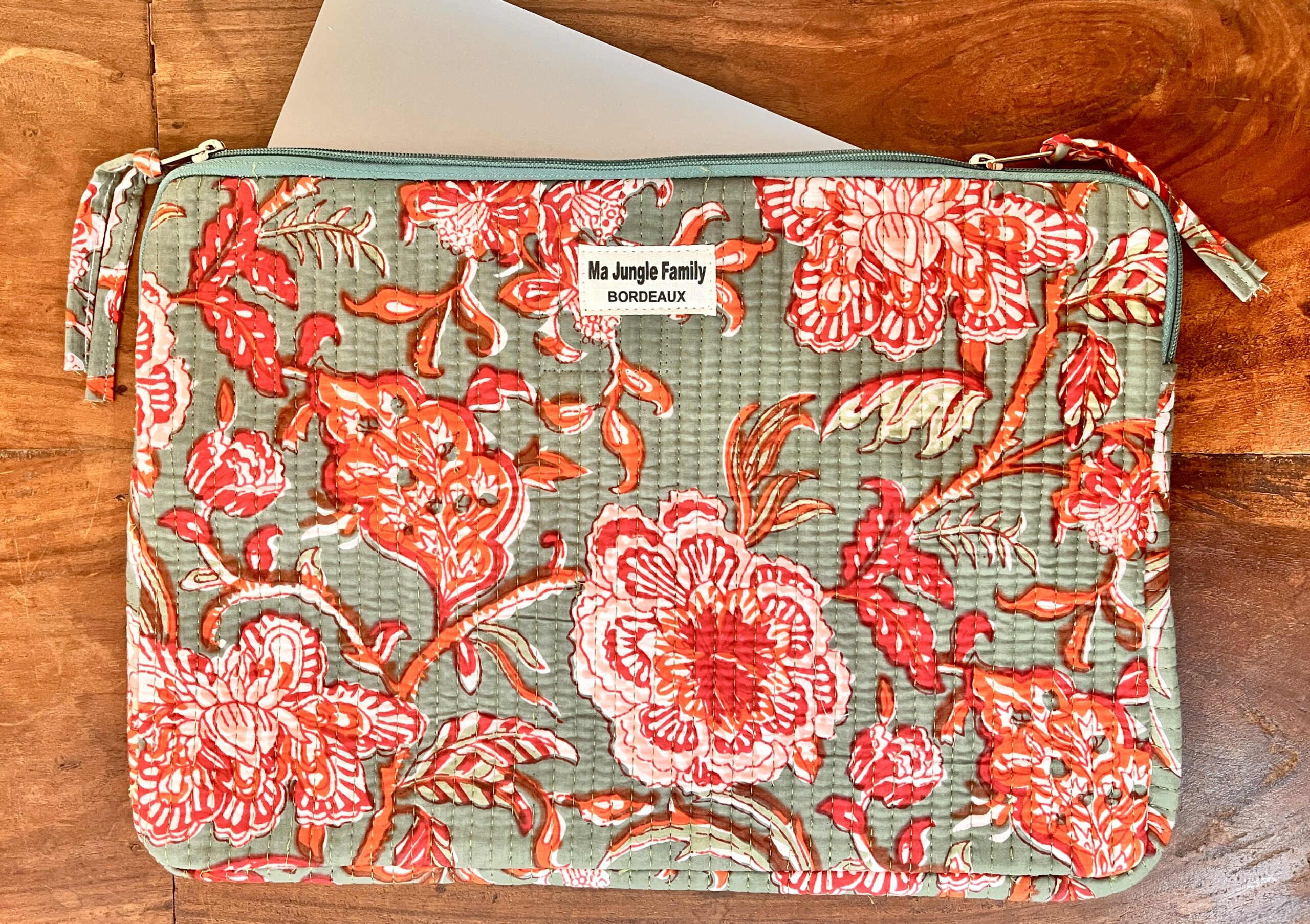 Housse d’ordinateur en coton indien matelassé avec imprimé floral block-print, format 15 pouces, faite main. Housse d’ordinateur artisanale en coton indien, motif original, utilisée pour transporter un laptop, Accessoire éthique : housse ordinateur bohème en coton imprimé, tenue à la main dans un décor naturel. Housse d’ordinateur Ma Jungle Family – coton indien artisanal – Bordeaux Fleuriste colorés hibiscus vert et orange