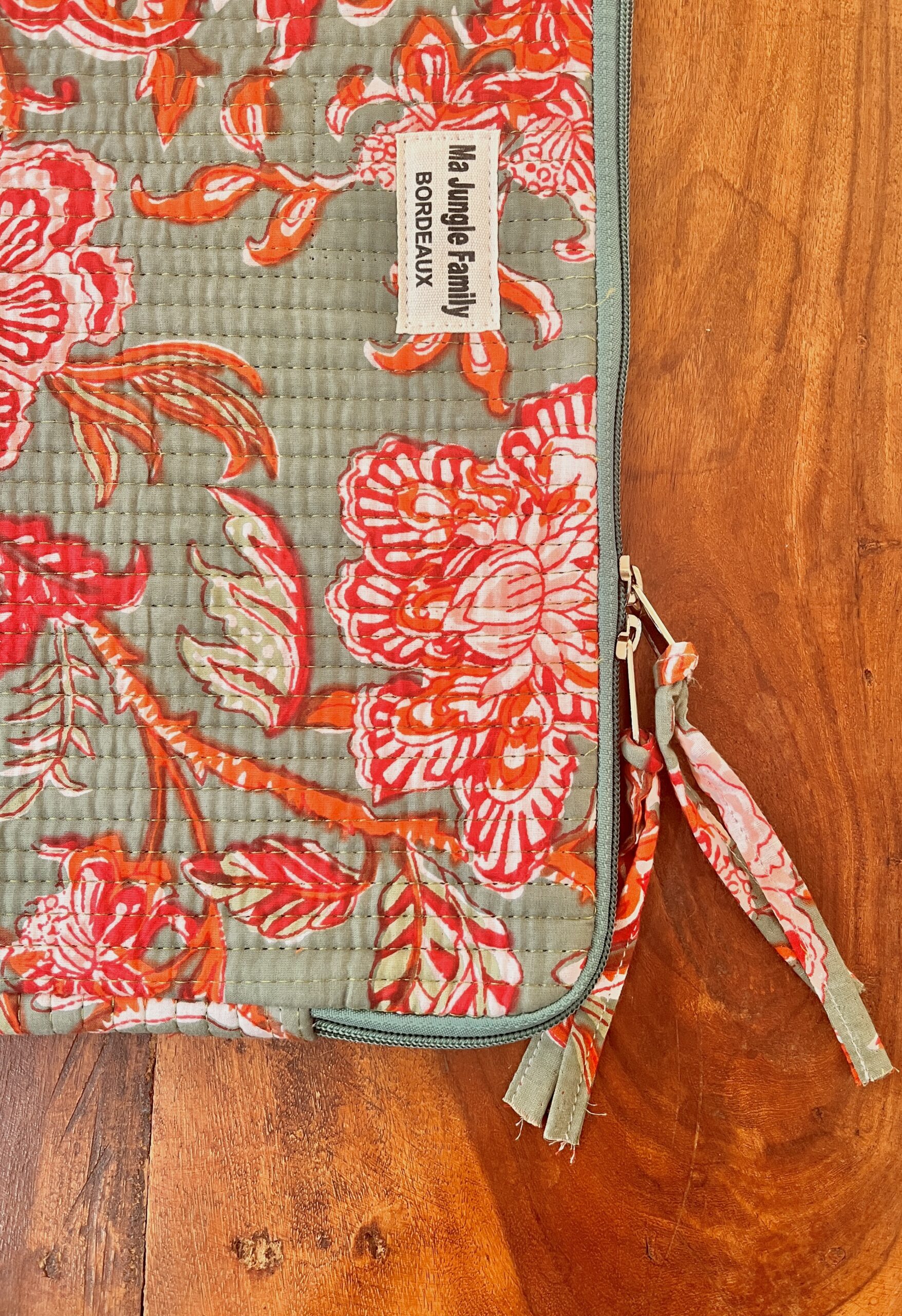 Housse d’ordinateur en coton indien matelassé avec imprimé floral block-print, format 15 pouces, faite main. Housse d’ordinateur artisanale en coton indien, motif original, utilisée pour transporter un laptop, Accessoire éthique : housse ordinateur bohème en coton imprimé, tenue à la main dans un décor naturel. Housse d’ordinateur Ma Jungle Family – coton indien artisanal – Bordeaux Fleuriste colorés hibiscus vert et orange