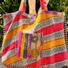 Tote bag kantha réversible en coton recyclé, cousu main à partir de saris indiens, avec poche extérieure et intérieure – modèle unique exposé en lumière naturelle.