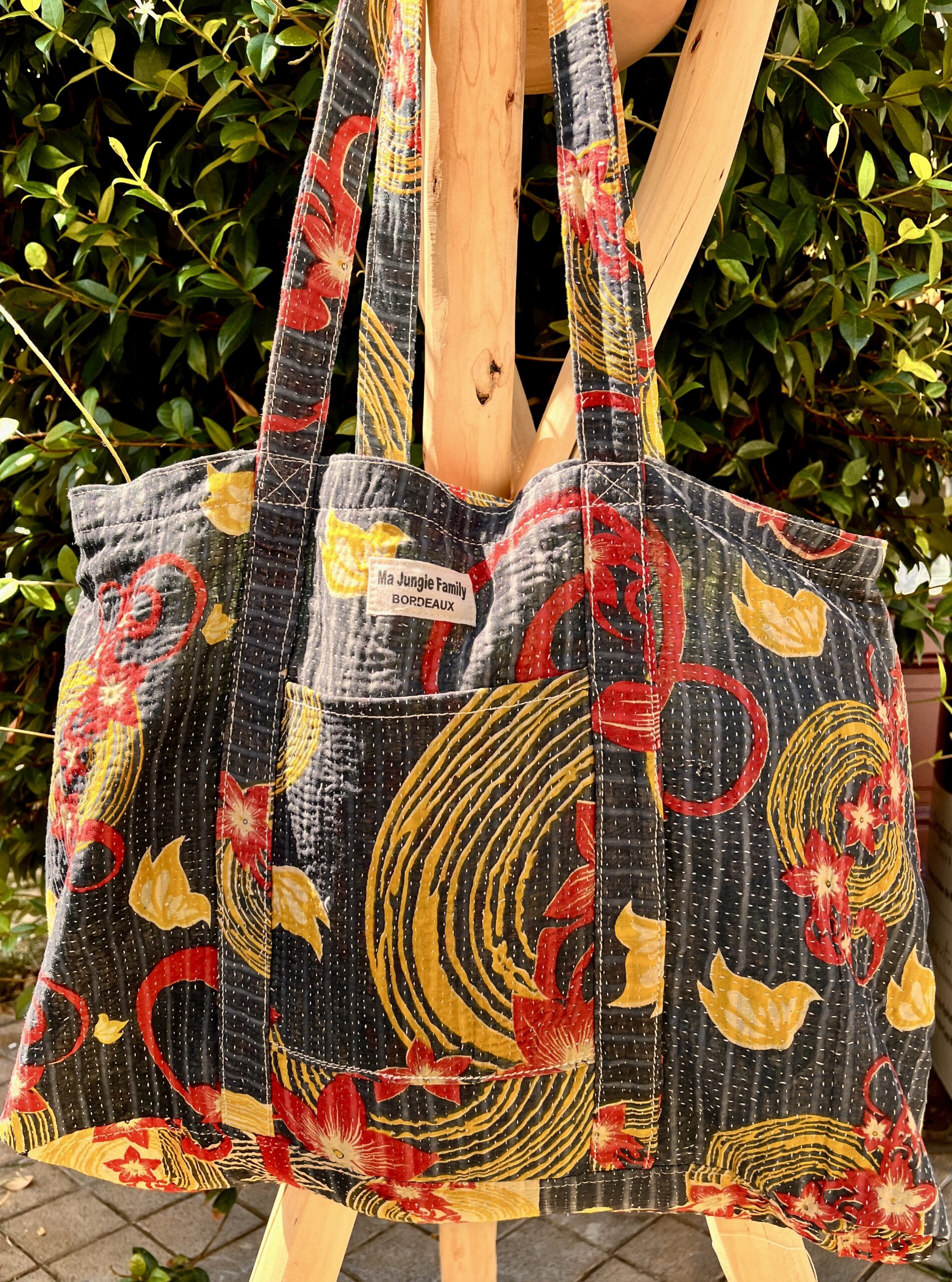 Tote bag kantha réversible en coton recyclé, cousu main à partir de saris indiens, avec poche extérieure et intérieure – modèle unique exposé en lumière naturelle.