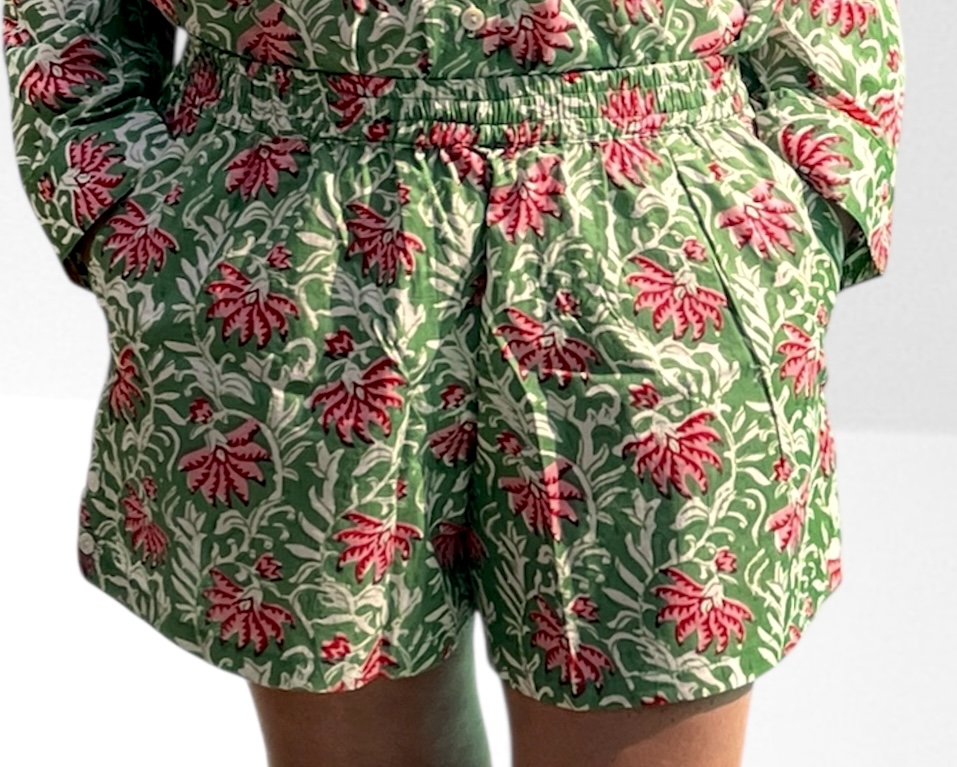 Cet ensemble unique associe le charme de l’artisanat indien et le savoir-faire de notre atelier bordelais. La chemise à col Mao, élégamment boutonnée avec de sublimes boutons en nacre, est imprimée à la main selon la technique ancestrale du block print en Inde. Le short assorti reprend les mêmes imprimés et se distingue par ses finitions soignées : poches latérales et arrières, petits boutons délicats sur les côtés, cuisses en nacre… chaque détail compte. Un look à la fois décontracté et raffiné, pensé pour celles qui aiment porter des pièces uniques, responsables et empreintes de voyage. Créé avec amour à Bordeaux, fabriqué à la main entre ici et ailleurs. Tissu fleuri vert et rose