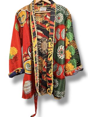 Veste kantha vintage réversible en coton recyclé, faite main à partir de saris indiens – pièce unique aux motifs fleuris colorés, exposée sur un portant. Rouge, vert, fleurs
